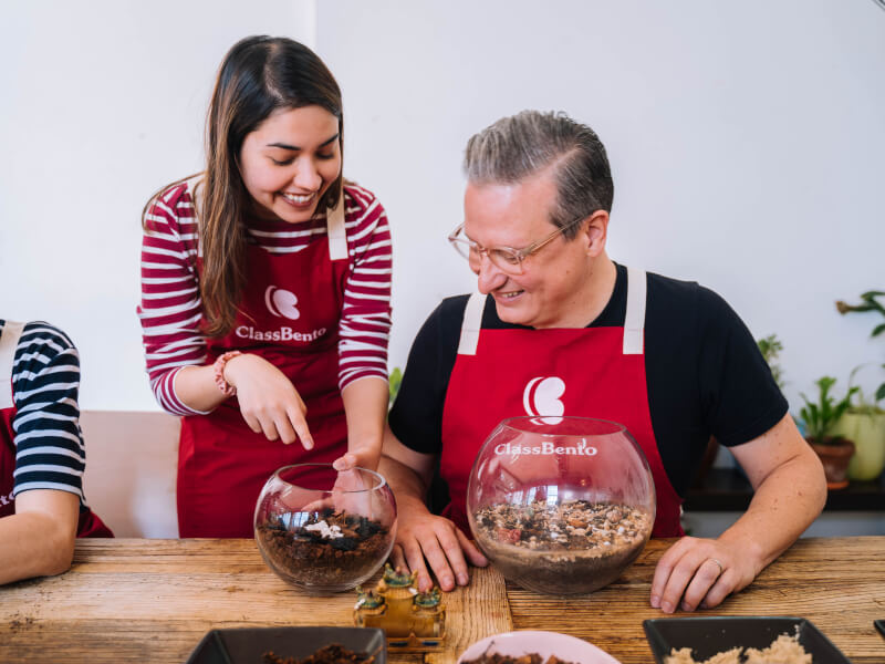 Teacher demonstrating craft to student at a terrarium making class